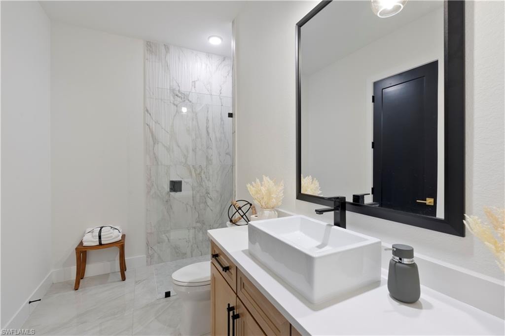 Full bathroom featuring vanity and a marble finish shower