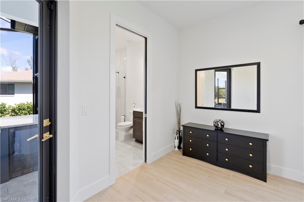 Bedroom featuring light wood-style flooring and ensuite bath