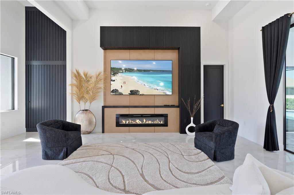 Bedroom with a glass covered fireplace, access to outside, and marble tiled flooring