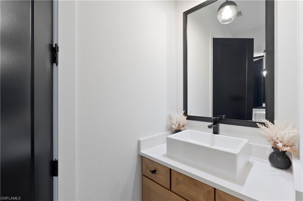 Bathroom featuring vanity and a textured wall