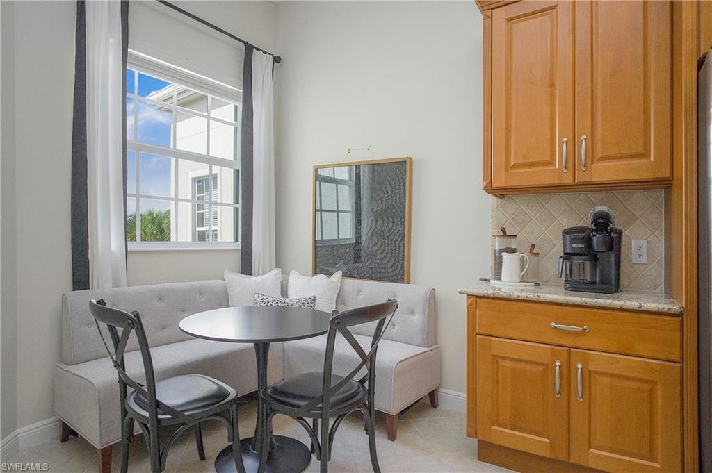 Dining space featuring light tile patterned floors and breakfast area