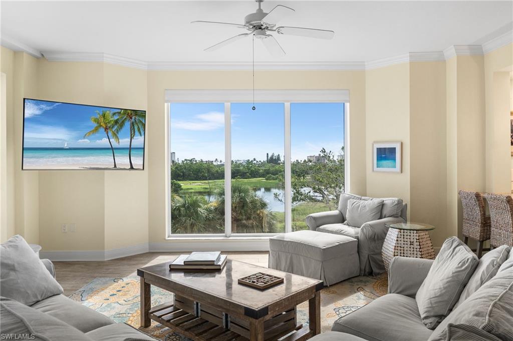 Living room featuring crown molding and a ceiling fan