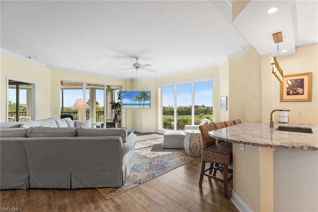 Living area with crown molding, wood finished floors, a ceiling fan, and recessed lighting