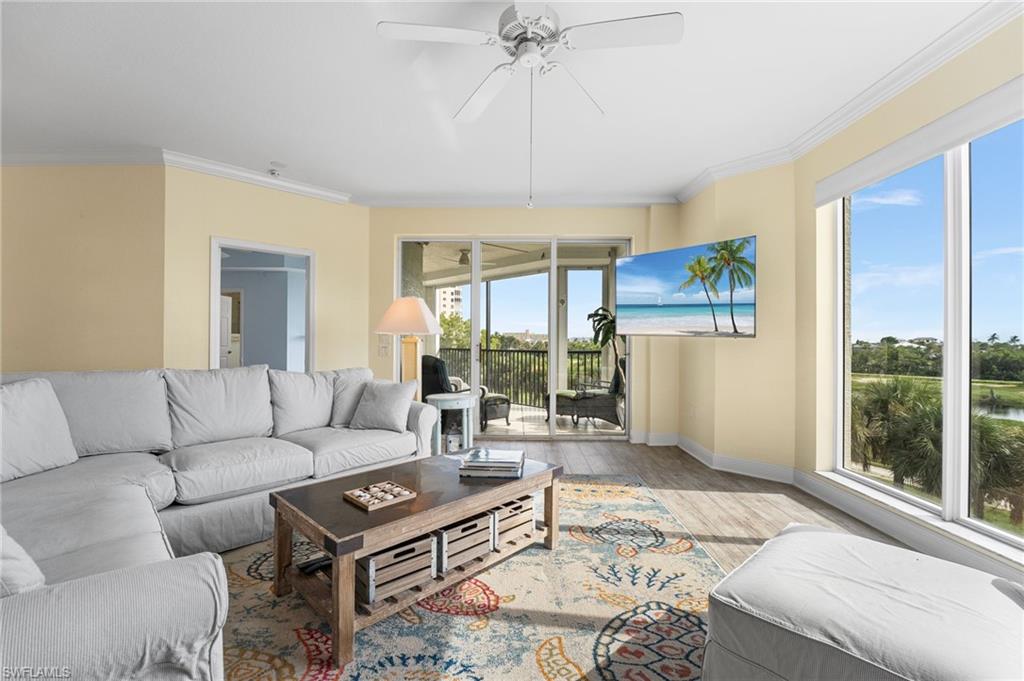Living area with crown molding, wood finished floors, and ceiling fan