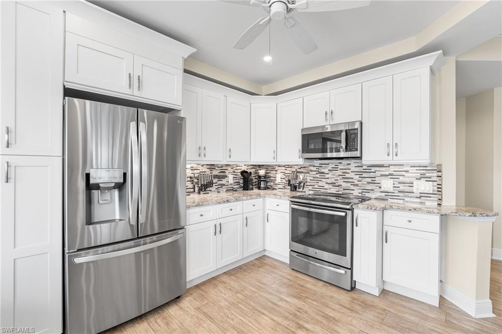 Kitchen featuring appliances with stainless steel finishes, light wood-type flooring, white cabinetry, backsplash, and recessed lighting