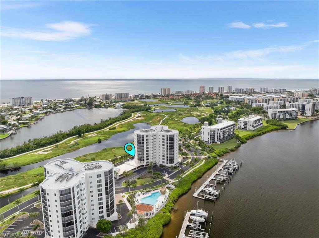 View of urban area with a nearby body of water and a pool