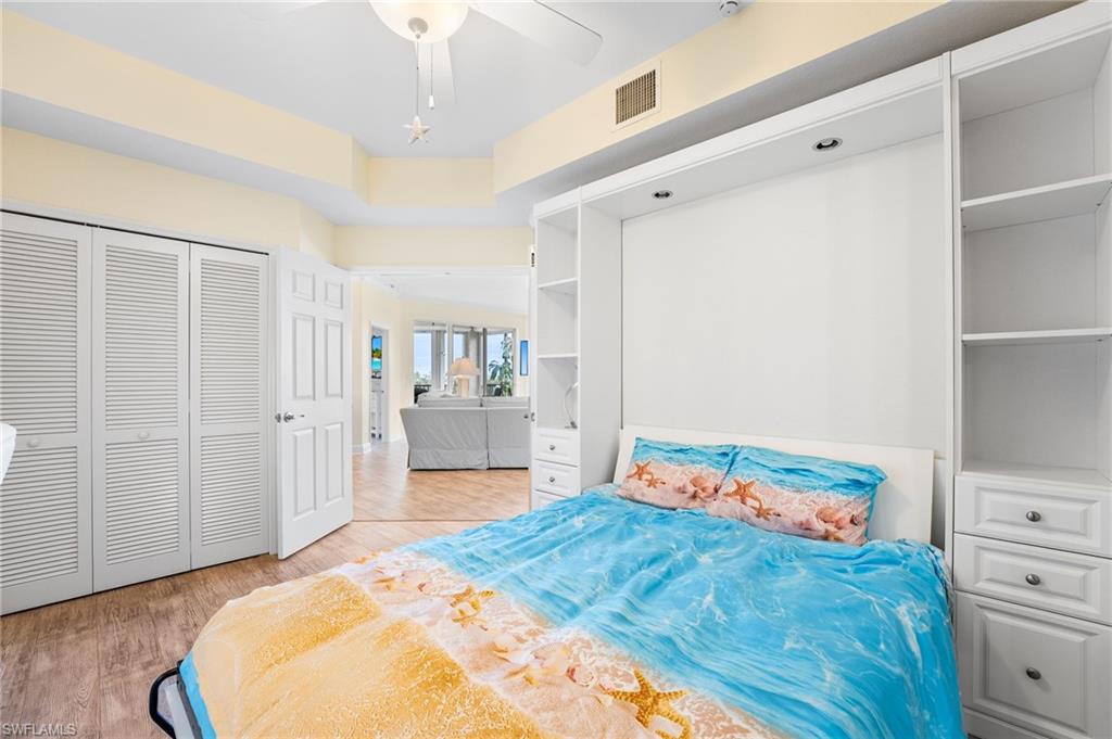 Murphy Bedroom featuring light wood-style floors, ceiling fan, and a closet