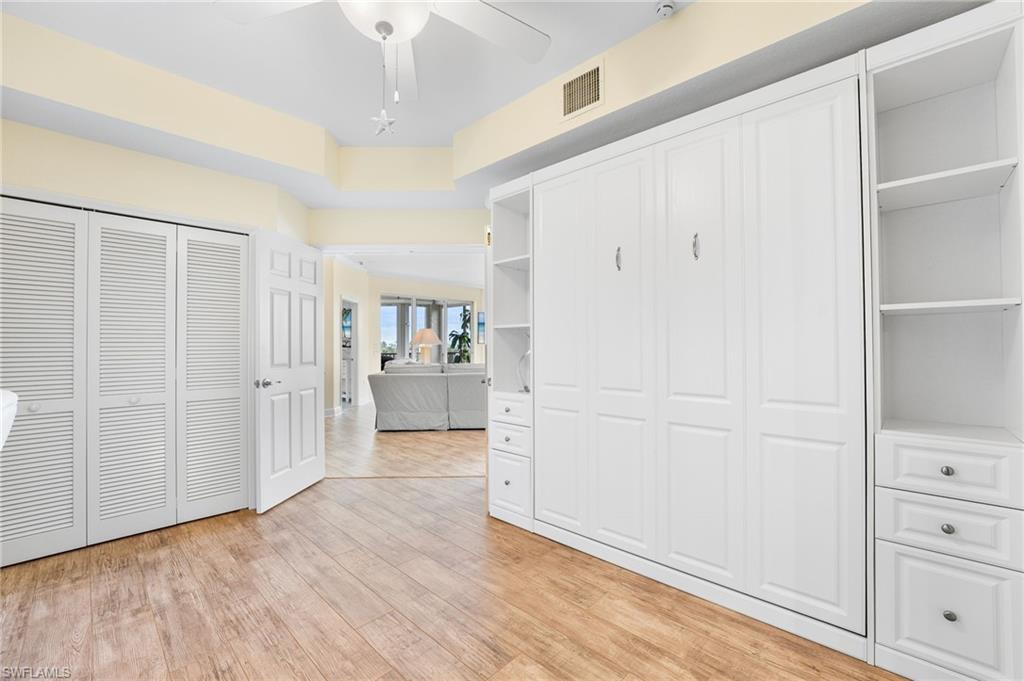 Murphy bedroom with light wood finished floors and a ceiling fan