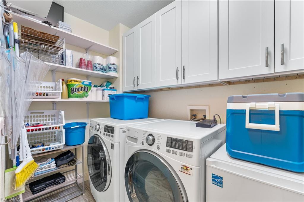 Laundry room featuring washing machine and clothes dryer and cabinet space