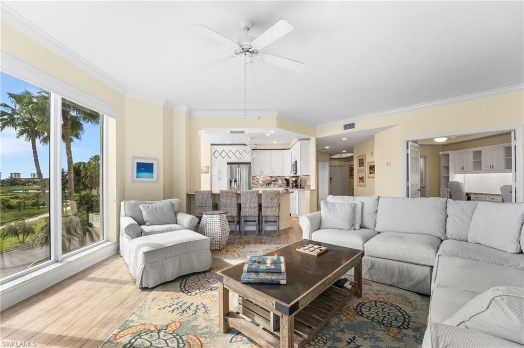 Living area featuring ornamental molding, a ceiling fan, and wood finished floors