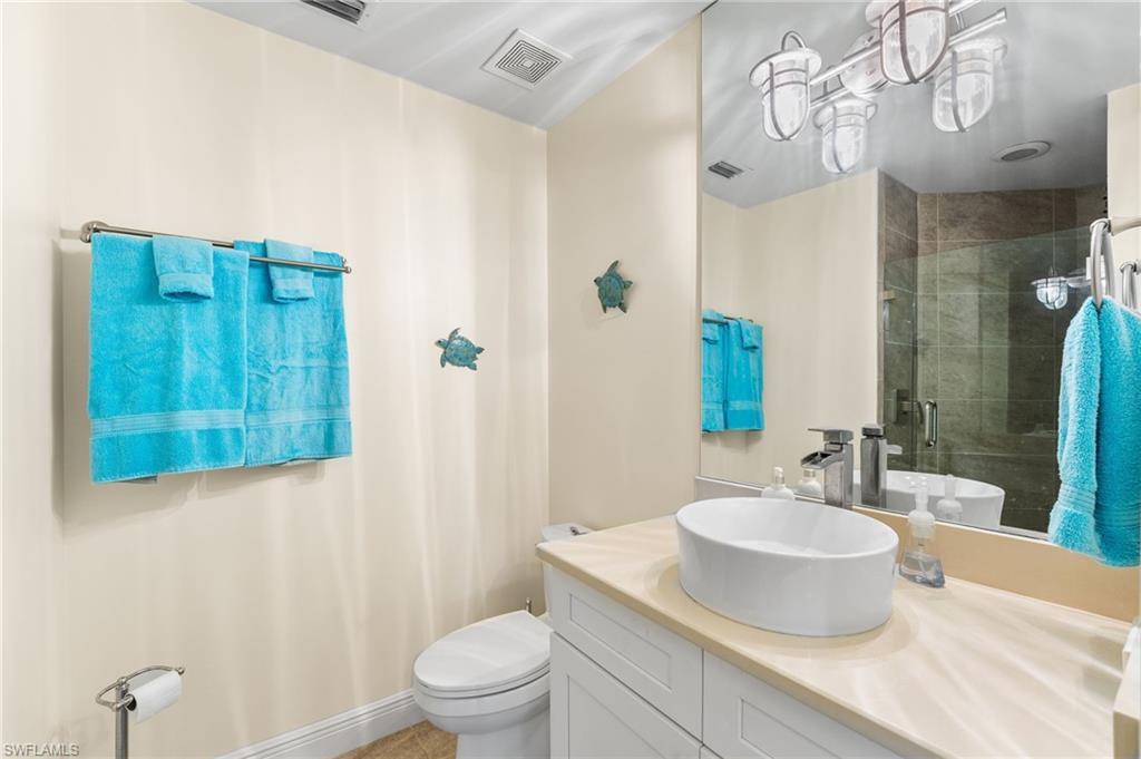 Full bath featuring a stall shower, vanity, and light tile patterned floors