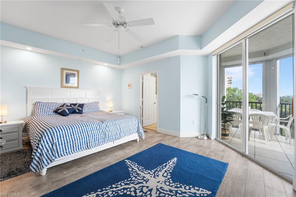 Bedroom featuring access to outside, wood finished floors, and a ceiling fan