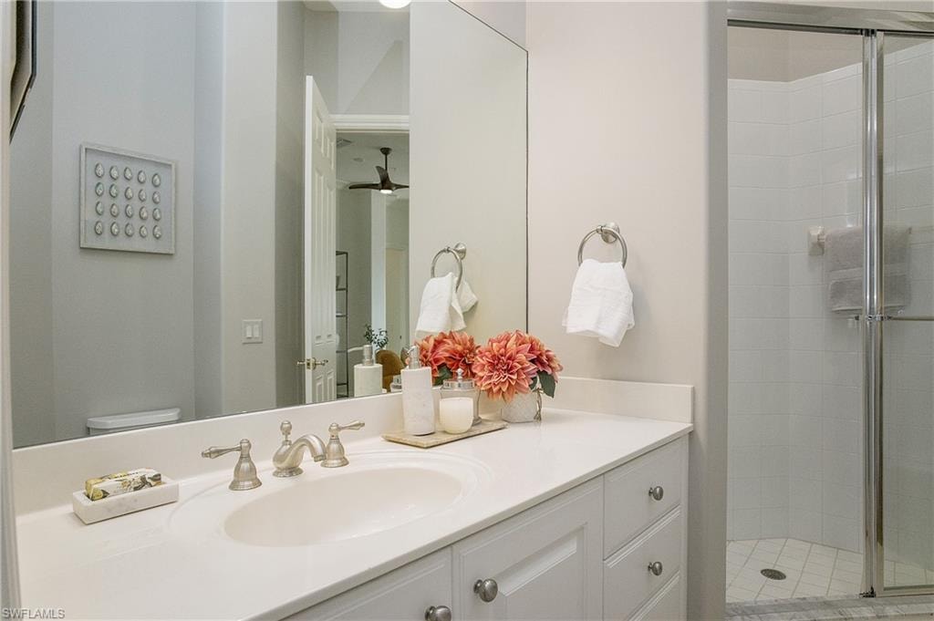 Bathroom with a shower with door, vanity, and toilet
