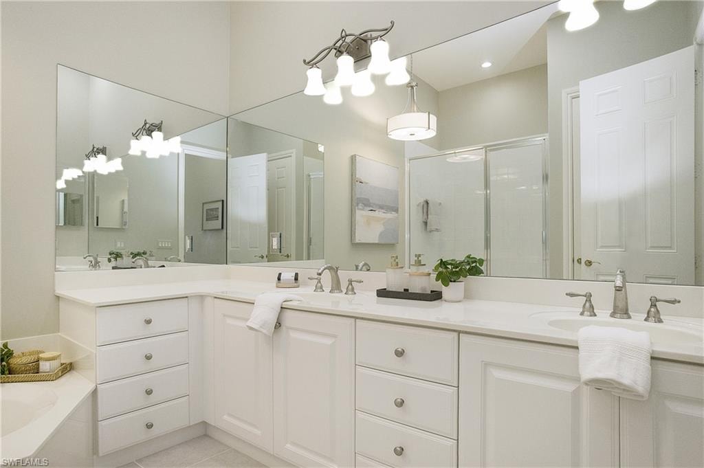 Bathroom featuring vanity, tile patterned flooring, and shower with separate bathtub