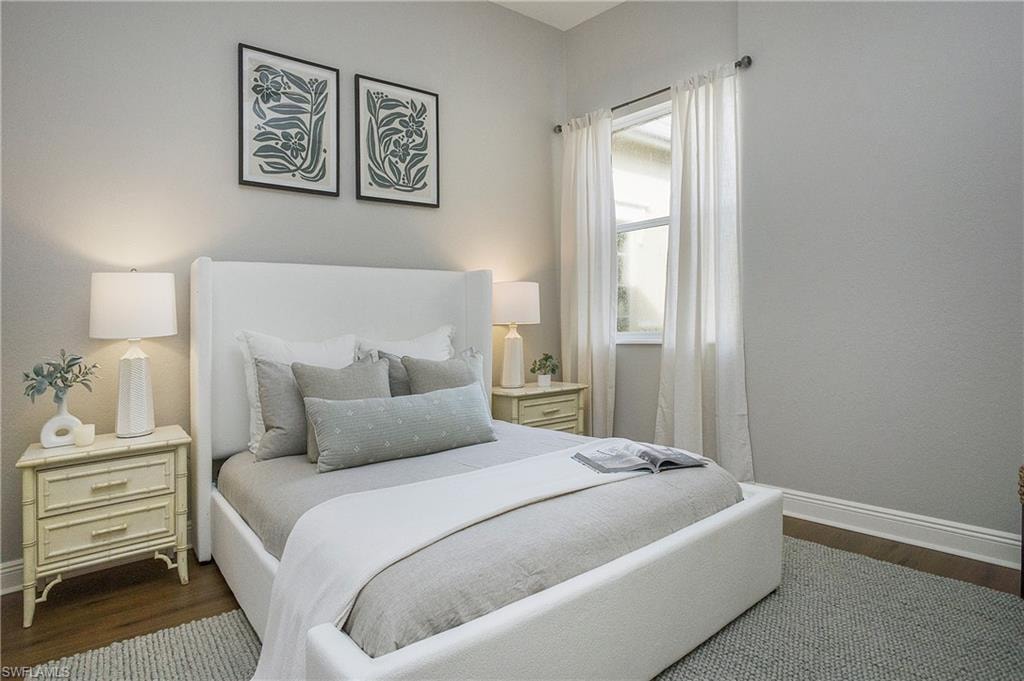 Bedroom with multiple windows and dark hardwood / wood-style floors