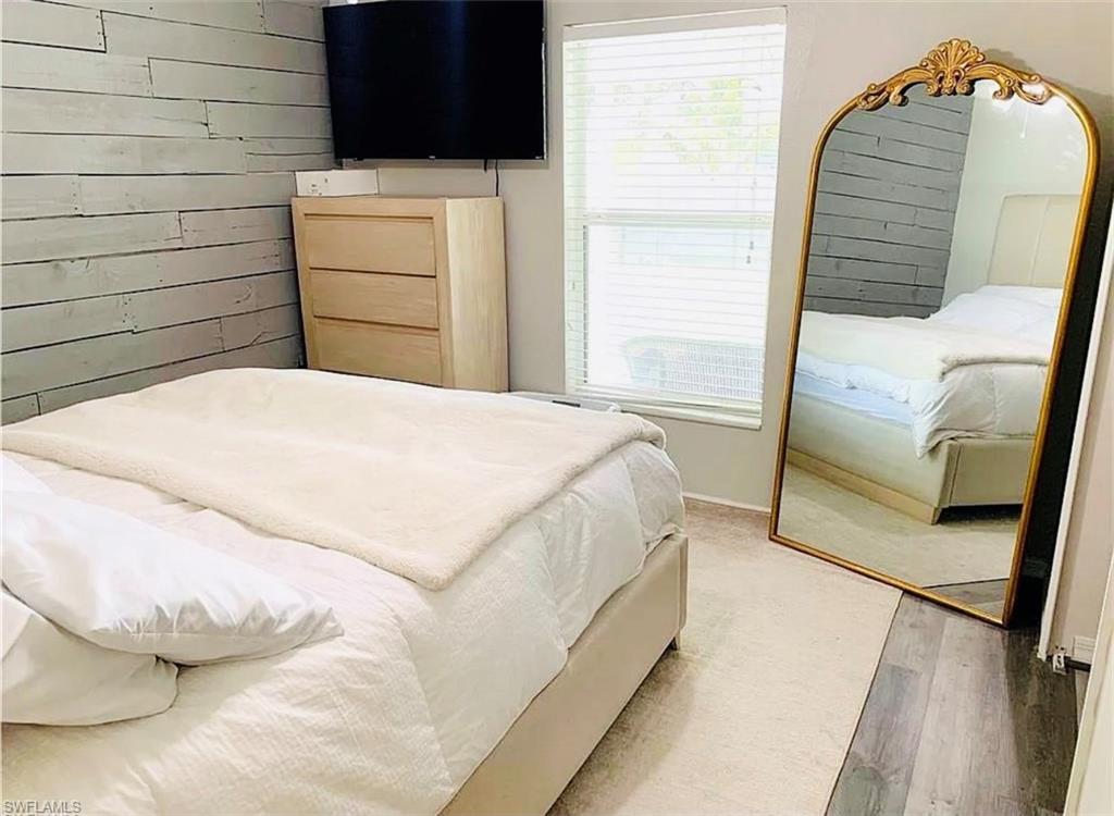 Bedroom featuring wooden walls and wood finished floors