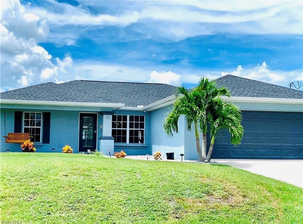 Ranch-style home with stucco siding, a front lawn, driveway, roof with shingles, and a garage
