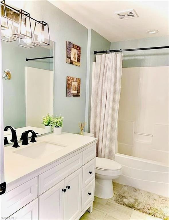 Full bath featuring vanity and shower / tub combo with curtain
