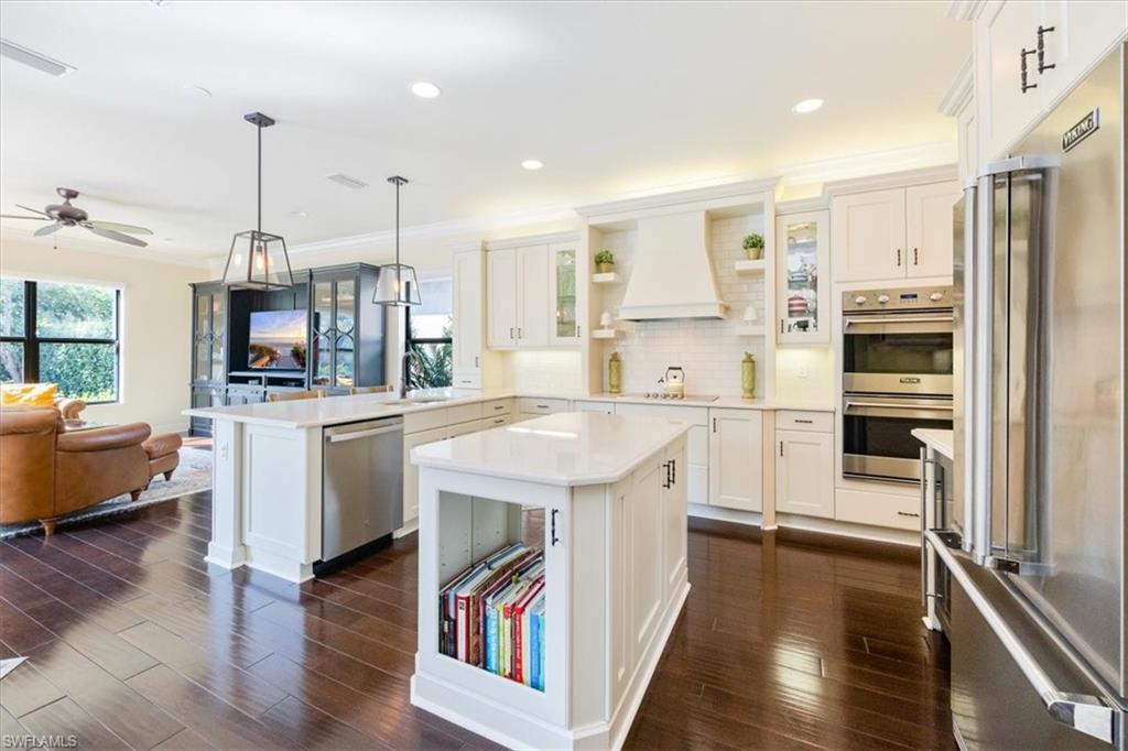 Kitchen featuring custom range hood, a center island, kitchen peninsula, and appliances with stainless steel finishes