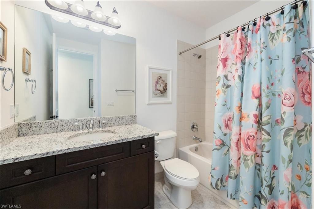 Full bathroom featuring toilet, shower / bath combo, and vanity