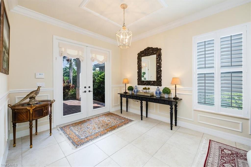 Entryway featuring a healthy amount of sunlight, french doors, crown molding, and light tile patterned floors