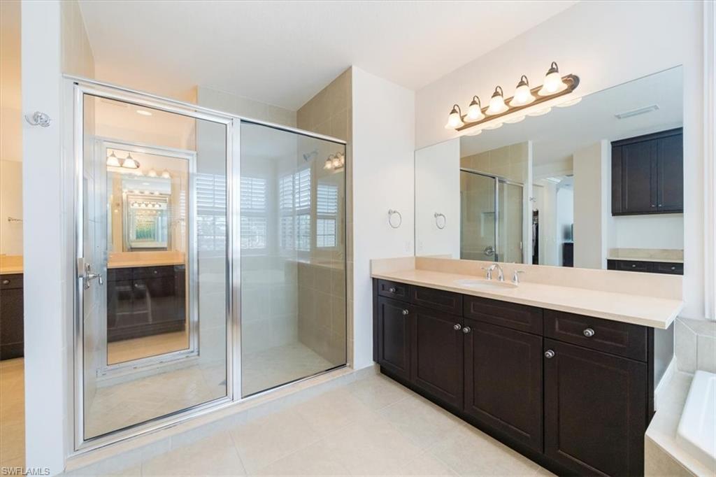 Bathroom with separate shower and tub, tile patterned flooring, and vanity