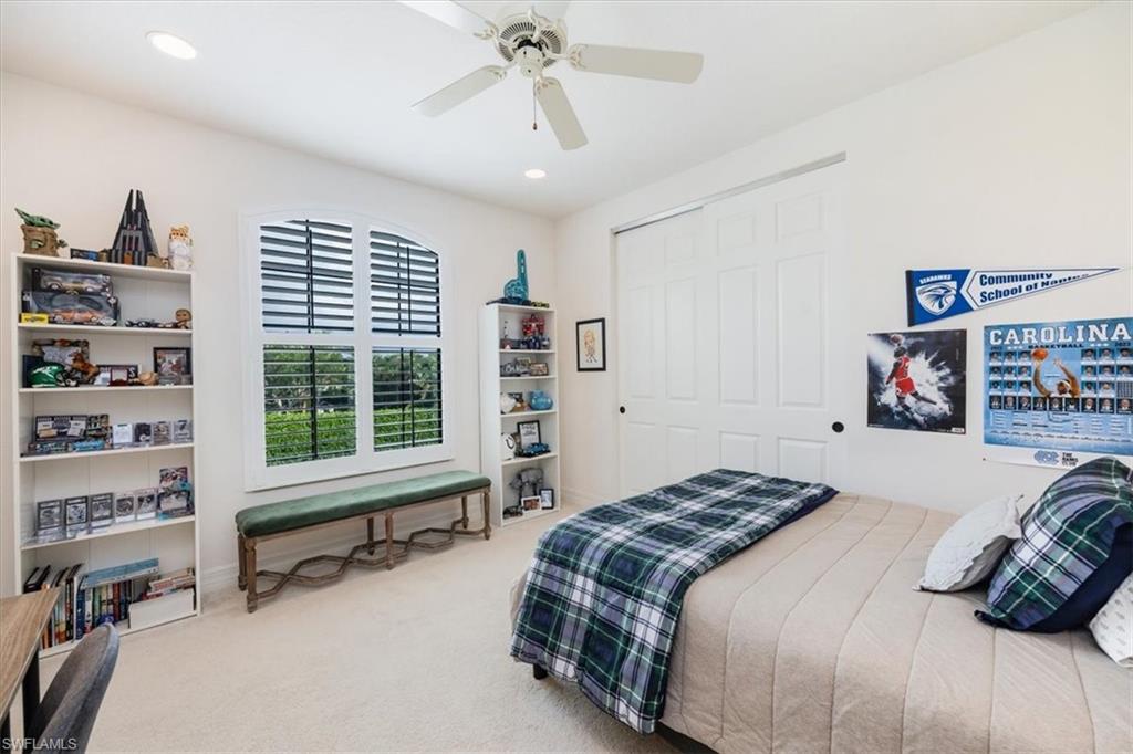 Carpeted bedroom featuring a closet and ceiling fan