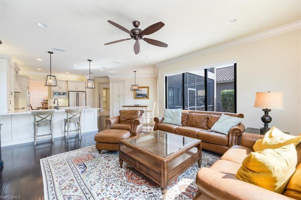 Living room with sink, dark hardwood / wood-style flooring, ceiling fan, and crown molding