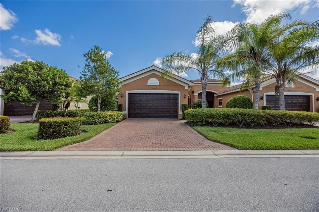 View of front of home featuring stucco siding, a garage, and decorative driveway