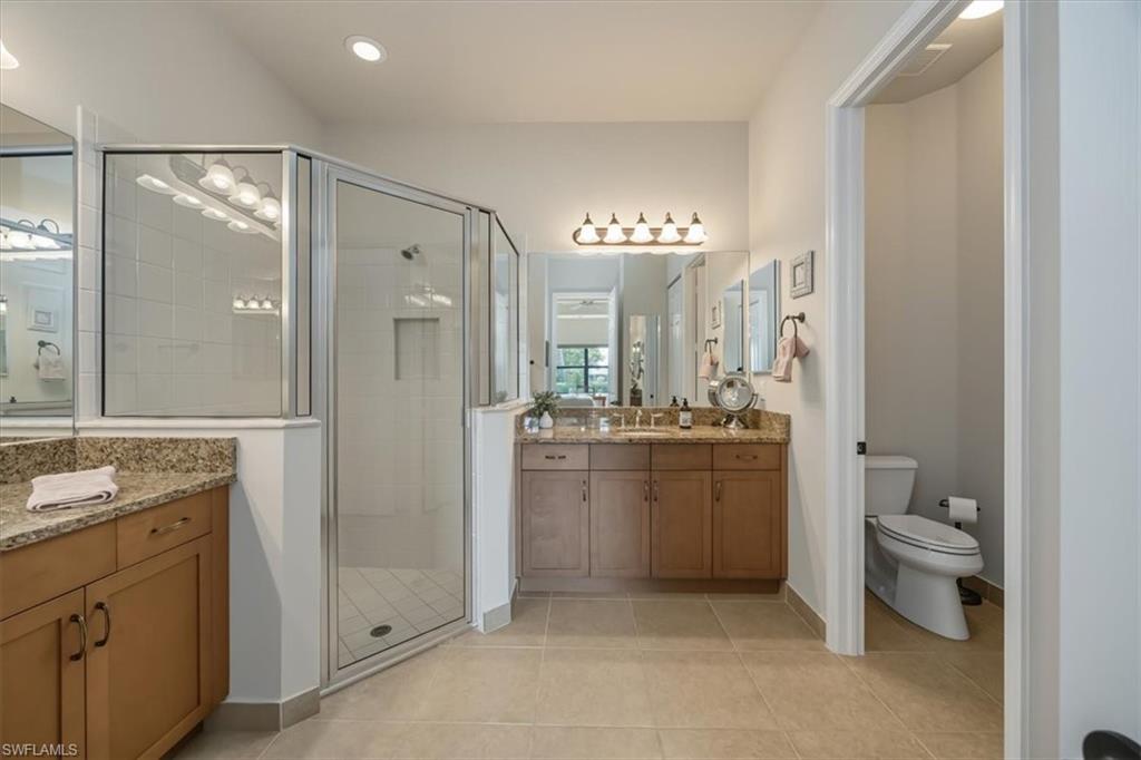 Bathroom with a stall shower, light tile patterned floors, and vanity