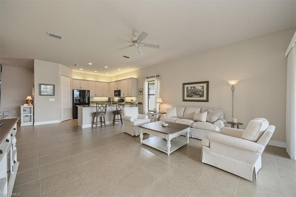 Living area with light tile patterned flooring, ceiling fan, and recessed lighting