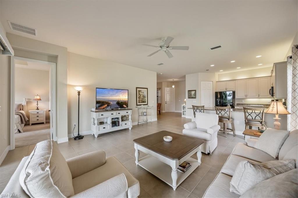 Living room featuring recessed lighting, light tile patterned flooring, and ceiling fan