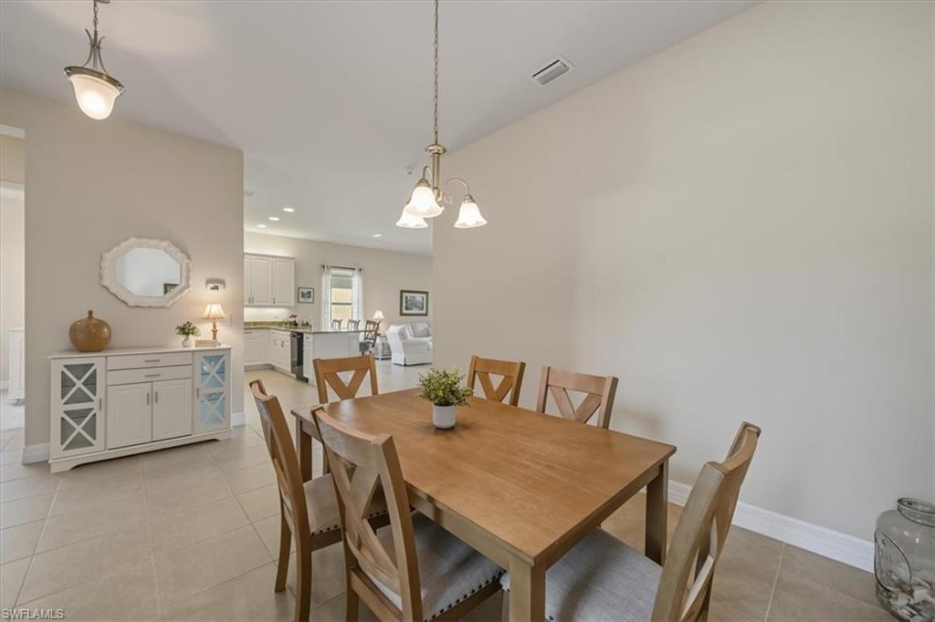 Dining room featuring light tile patterned floors, recessed lighting, and a chandelier