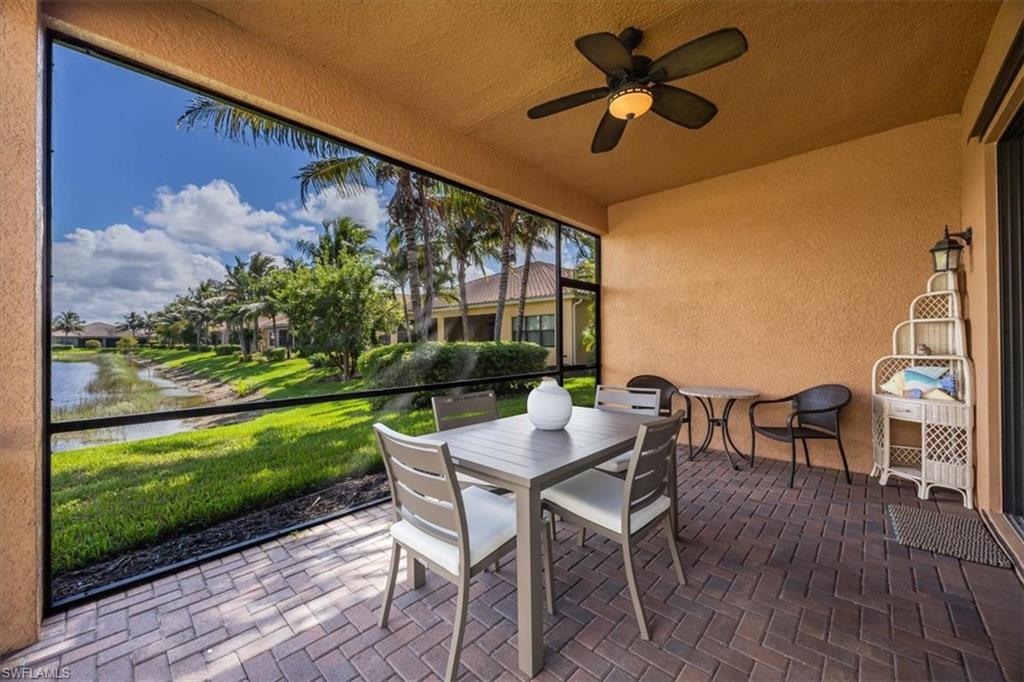Sunroom / solarium with outdoor dining space, a ceiling fan, a water view, and a patio area