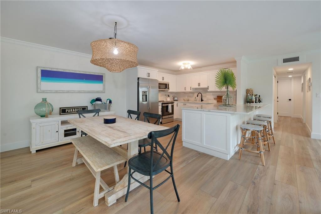 Dining space with crown molding and light wood-style flooring