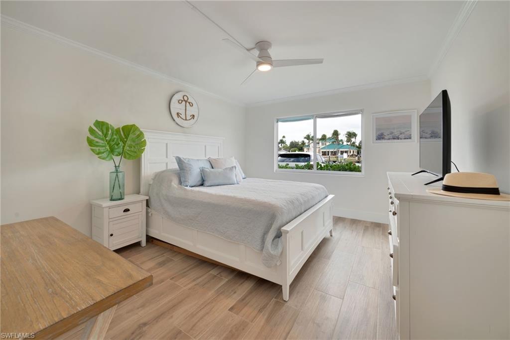 Bedroom featuring ornamental molding, light wood finished floors, and ceiling fan