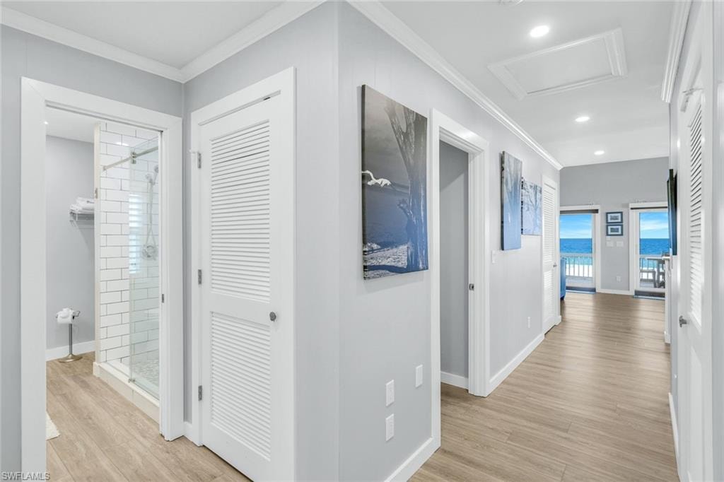 Hall featuring light wood finished floors, attic access, ornamental molding, and recessed lighting