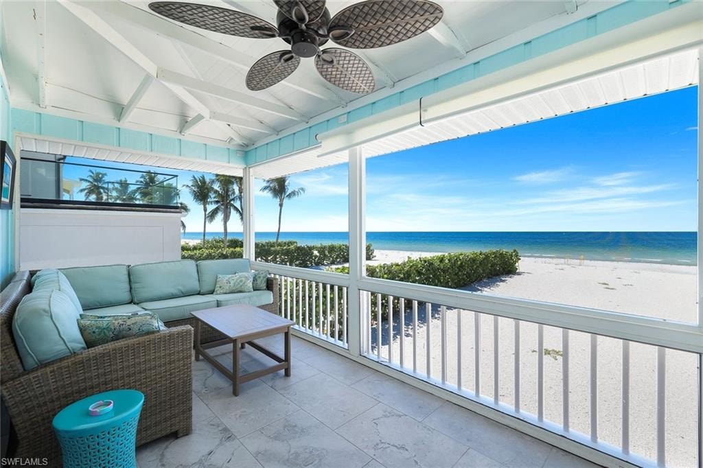 Sunroom / solarium with view of water and beach and plenty of natural light