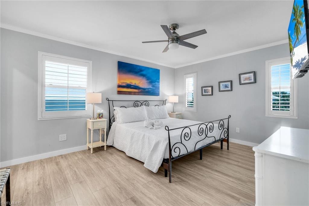 Bedroom featuring crown molding, light wood-type flooring, and ceiling fan