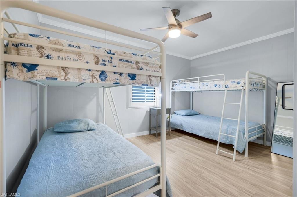 Bedroom featuring ornamental molding, light wood-style flooring, and a ceiling fan