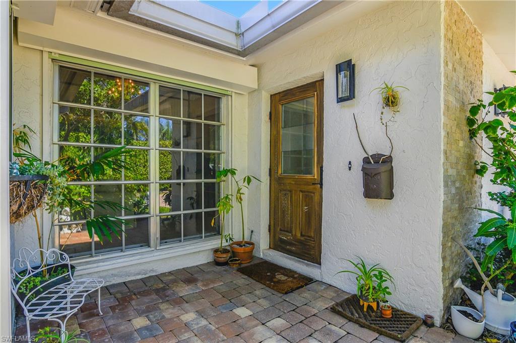 Property entrance with stucco siding and a patio area