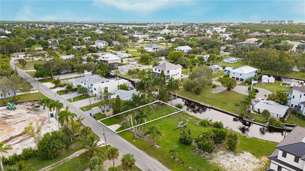 Aerial view of property and surrounding area featuring nearby suburban area
