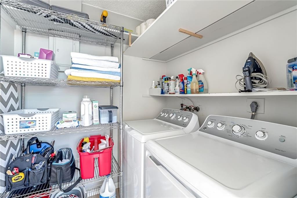 Laundry area featuring washer and dryer and a textured ceiling