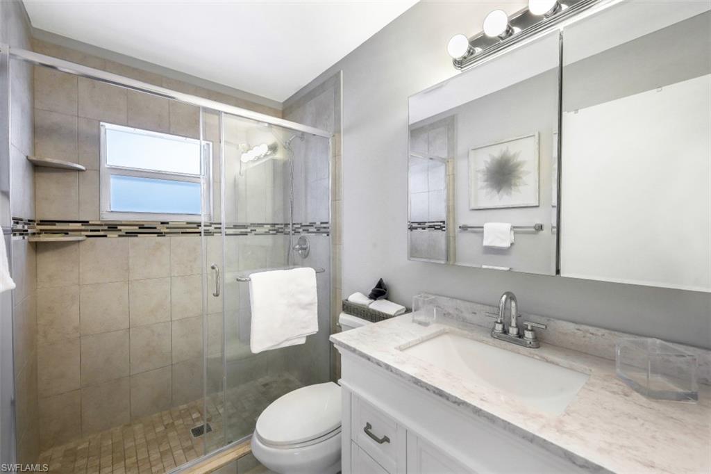 Full bathroom with vanity and a shower stall