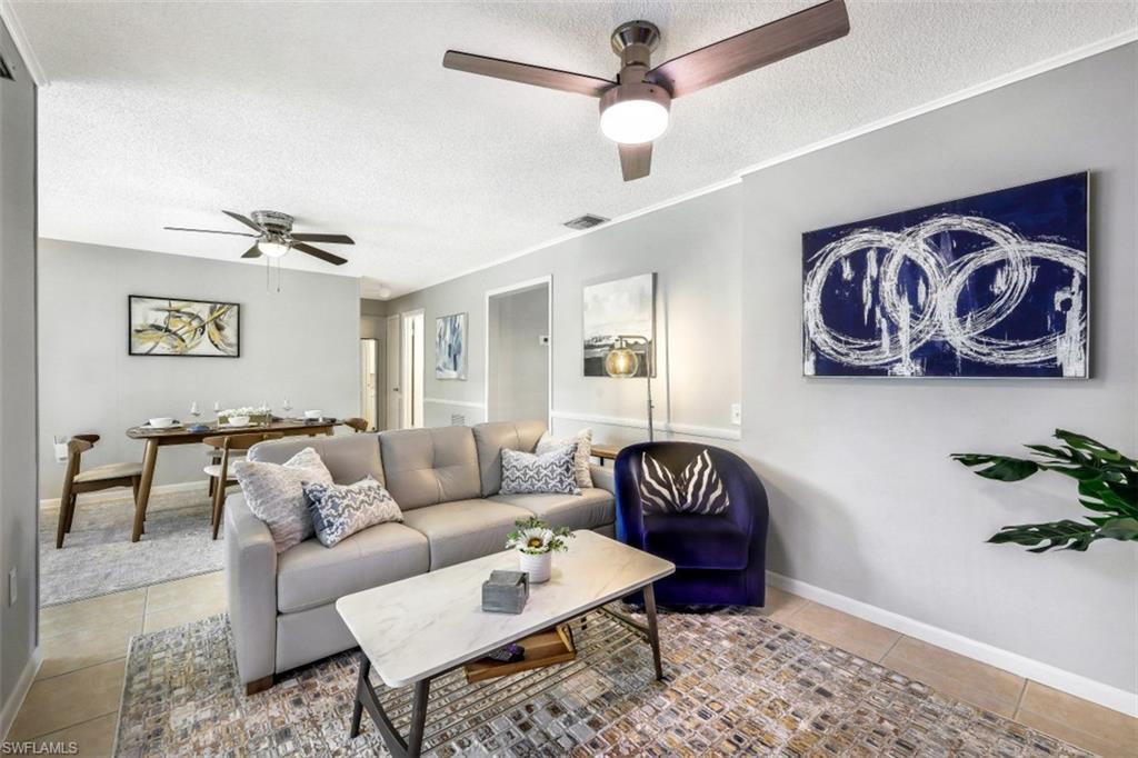Tiled living room featuring a textured ceiling and ceiling fan