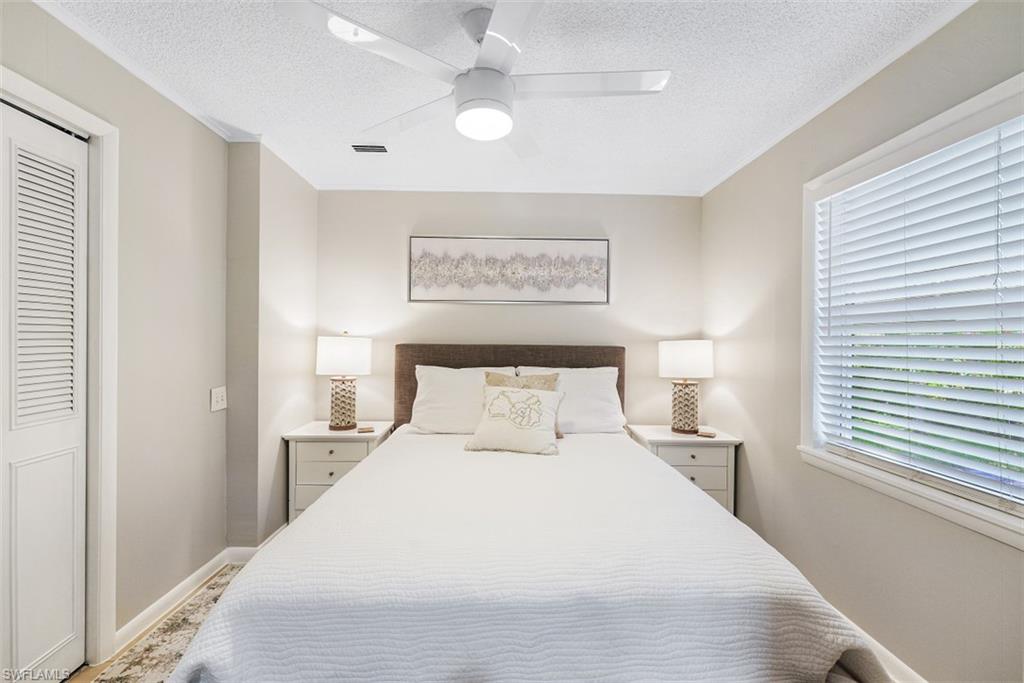 Bedroom with a textured ceiling, ceiling fan, a closet, and crown molding