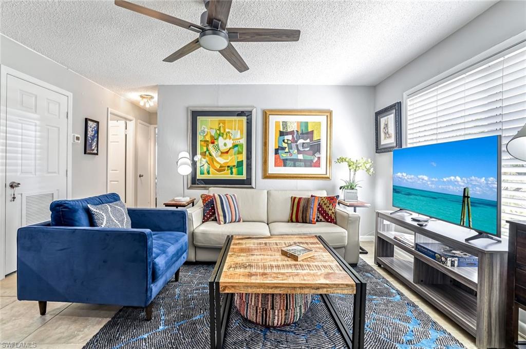 Living area featuring a textured ceiling and a ceiling fan