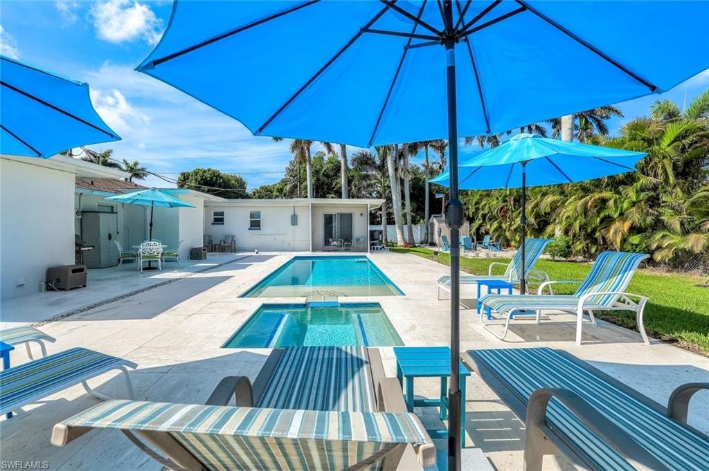 View of pool featuring a patio area and a pool with connected hot tub