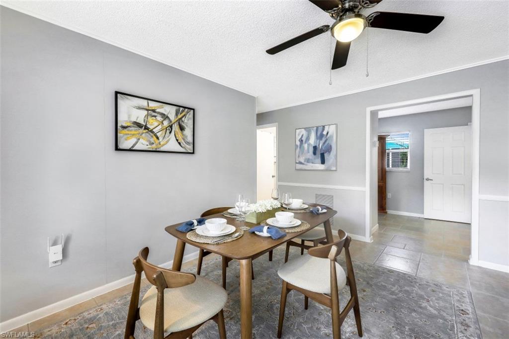 Dining area featuring a textured ceiling, a ceiling fan, and crown molding