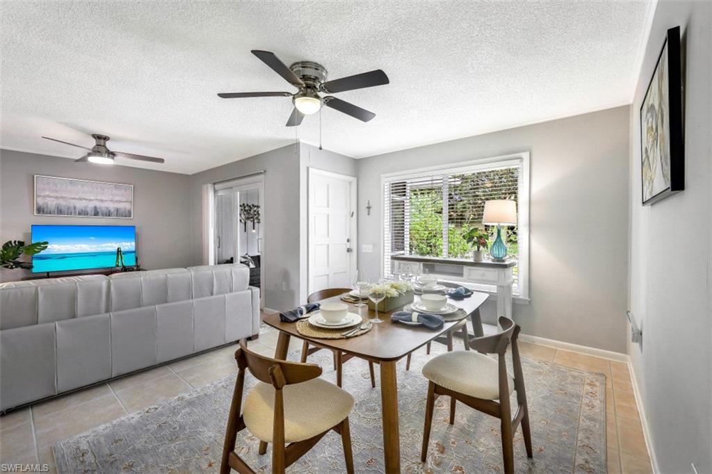 Dining area featuring a textured ceiling, light tile patterned floors, and a ceiling fan
